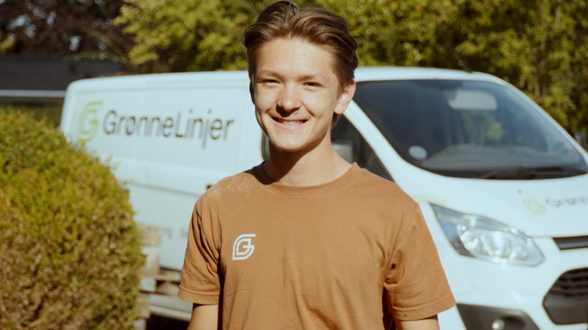 Medarbejder fra Grønne Linjer foran firmabilen